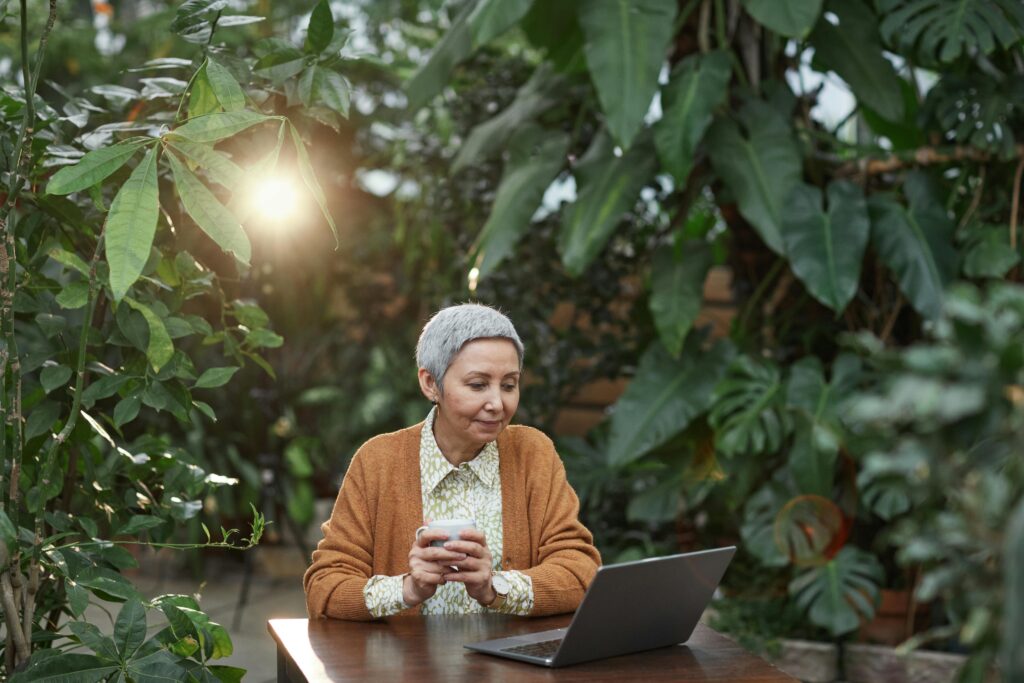 Woman Looking at Her Laptop and sittingg in the garden