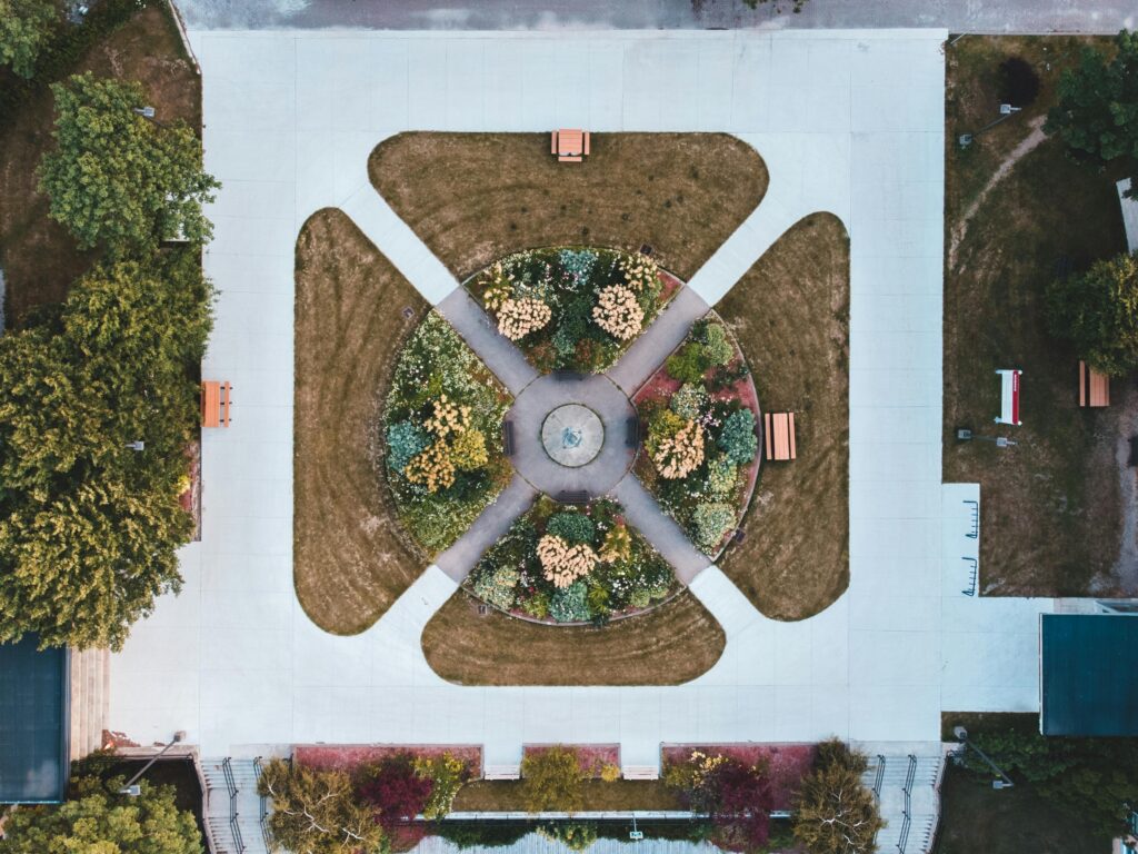 pexels-photo-8811590-8811590 Top view of a neatly arranged roundabout garden in a park, captured by a drone.